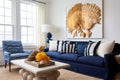 a bright room with white walls, navy blue sofa, and seashell decorations Royalty Free Stock Photo