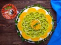 Bright round festive fruit cake decorated with kiwi, orange, mint and a glass. Royalty Free Stock Photo