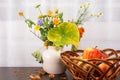 Bright rustic bouquet of flowers, apples in a wicker bowl