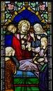 Stained glass window depicting Christ with sick woman. Royalty Free Stock Photo