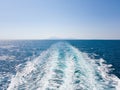 Bright sea water trail behind a cruise ship summer time. Ferry boat leaves a trail in a blue and clear water of Royalty Free Stock Photo