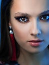 Bright sexy makeup and red tassel earrings. Portrait of a brunette girl.