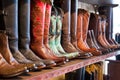 Bright shiny cowboy boots standing on a shelf in craft shop Royalty Free Stock Photo