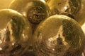 Bright and shiny golden-colored ornaments or balls and viewed in close-up. Royalty Free Stock Photo