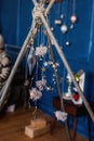 Bright shiny stars, Christmas tinsel on blue background hang on bamboo sticks of the wigwam Royalty Free Stock Photo