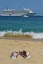 Bright shoes on a beach in Cabo San Lucas Mexico on a summers day with a cruise ship in the background.