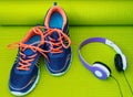 Bright Shoes and Headphones on Rolled Yoga Mat