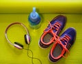 Bright Shoes, Headphones and Water Bottle on Rolled Yoga Mat