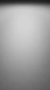 Subtle textured grey surface with soft lighting and a gradient from dark to light creating a minimalist abstract background for Royalty Free Stock Photo