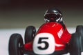 Bright silver helmet on a racing driver on a red toy vintage racing car Royalty Free Stock Photo