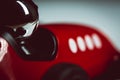 Bright silver helmet on a racing driver on a red toy vintage racing car Royalty Free Stock Photo