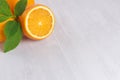 Bright slice oranges closeup texture and green leaves on white wood background, top view.