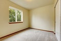 Bright small empty room with carpet floor, one window.