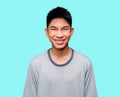 A bright smiling Asian young man looks happy with a mesmerizing expression and is shocked against a blue background. Cheerful men Royalty Free Stock Photo