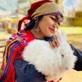 Bright smiling lady in Traditional Manali Costume for women with silver jewellery and cute rabbit