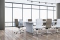 Bright spacious meeting room interior with white chairs, wooden parquet flooring and panoramic window with city view. Royalty Free Stock Photo