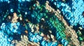 Bright spangles on a aqua green and golden fabric textile texture shiny background