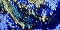 Bright spangles on a blue celebratory fabric textile texture shiny background