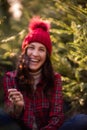 Bright sparkler in hands near defocused background of young woman in red checkered shirt Royalty Free Stock Photo