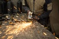 Bright sparks flying when grinding a metal structure by a worker