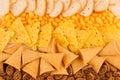 Bright spicy snacks collection - nachos, ruddy toasts, rye croutons, corn sticks as chess background. Top view, closeup.