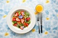 bright spinach and strawberry salad, blue napkin contrast