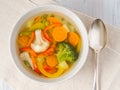 Bright spring vegetable soup with cauliflower, broccoli, pepper, carrot, green peas. Top view, white wooden background. Royalty Free Stock Photo