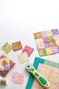 Bright square pieces of fabric, quilting tools, sewing equipment, traditional patchwork, space for text