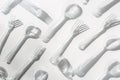 Bright and sterile composition white plastic forks and spoons spread over plain background with gentle shadows, image for culinary Royalty Free Stock Photo