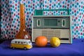 Bright still life with a tape recorder, toy car, vase, orange and lemon