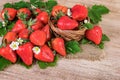 Bright strawberry with green leaves on light brown background Rustic still life