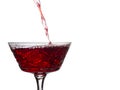 Bright stream of red wine pours into a vintage glass