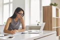 Bright student taking notes in notebook and using laptop computer for e-learning Royalty Free Stock Photo