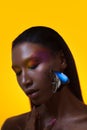 Bright stylish black woman on a yellow background with a blue butterfly on her face. Royalty Free Stock Photo