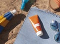 Bright summer beach vacation or travel lifestyle concept with sunscreen cream, sunglasses, sun umbrella on the sand. Royalty Free Stock Photo