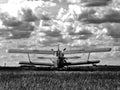 Double winged old classic airplane in rural air field. dynamic sky. black and white finish Royalty Free Stock Photo