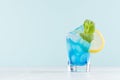 Bright summer fresh blue fruit cocktail with blue curacao liquor, ice cubes, sugar rim, green mint, lemon in pastel mint interior Royalty Free Stock Photo