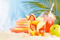 Bright summer fruit salad with sliced fruit - strawberry, mango, grapefruit, apple in plastic box with cold juice, sun hat on sun. Royalty Free Stock Photo