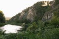 Bright summer landscape with river in rocky canyon with lush green coniferous forest in golden morning sunlight and grass. Royalty Free Stock Photo