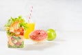 Bright summer lunch set with seafood salad with shrimps, red bell pepper, lettuce, croutons in plastic pack, fresh orange juice. Royalty Free Stock Photo