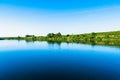 Bright summer nature panorama, forest trees and river with reflection in water, vivid tranquil and relax background