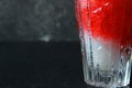 Bright, summer refreshing drink in a tall glass with crushed ice on a dark background. Top view with copy space