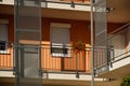 Bright summer scene of stucco elevation detail of apartment with geranium and steel railing