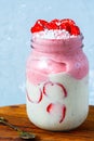 Bright summer strawberry-banana smoothie with coconut in a jar. Royalty Free Stock Photo