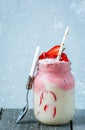 Bright summer strawberry-banana smoothie with coconut in a jar. Royalty Free Stock Photo