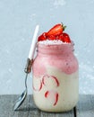 Bright summer strawberry-banana smoothie with coconut in a jar. Royalty Free Stock Photo