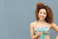 Bright summer trendy portrait of young fit Latina girl walking on the street, wearing vivid crop top, long curly afro hair