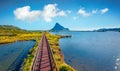 Bright summer view from flying drone wooden footbridge to Spiaggia di Porto Taverna beach. Royalty Free Stock Photo