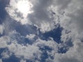 The bright sun in the blue sky covered with clouds Royalty Free Stock Photo