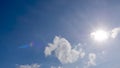 Bright sun in blue sky with fluffy clouds in sunny day. summer  runrays star shape, sunlight shine through white clouds, sunbeam Royalty Free Stock Photo